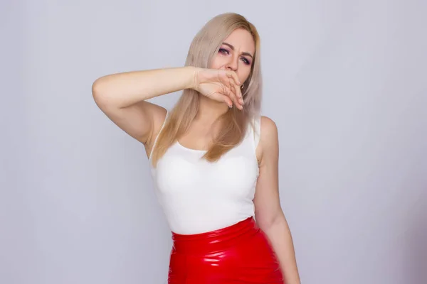 Donna bionda con gonna in pelle rossa e camicia bianca — Foto Stock