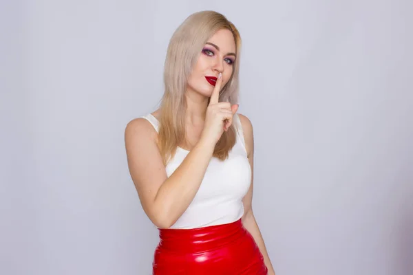 Femme blonde en jupe en cuir rouge et chemise blanche — Photo