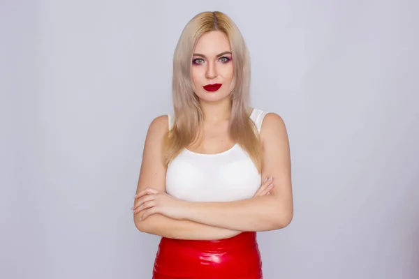 Mulher loira em saia de couro vermelho e camisa branca — Fotografia de Stock