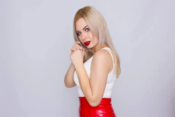 Mujer rubia en falda de cuero rojo y camisa blanca —  Fotos de Stock