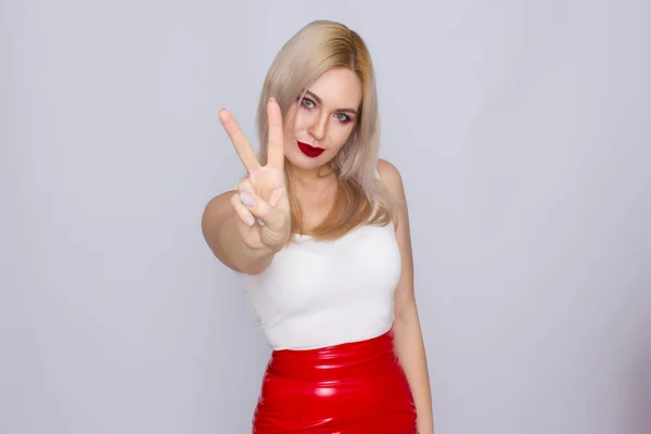 Femme blonde en jupe en cuir rouge et chemise blanche — Photo