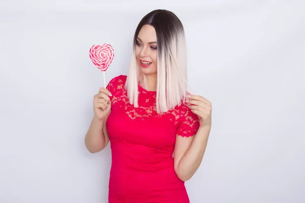 Blonde woman with heart candy in her hands
