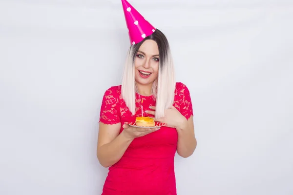 Blondine im Partyhut mit Kuchen — Stockfoto