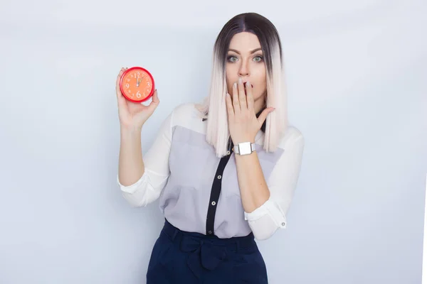 Mulher loira segurando despertador vermelho em suas mãos — Fotografia de Stock