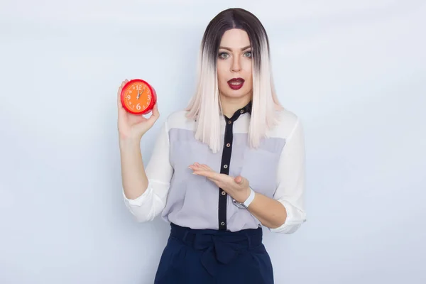 Mulher loira segurando despertador vermelho em suas mãos — Fotografia de Stock