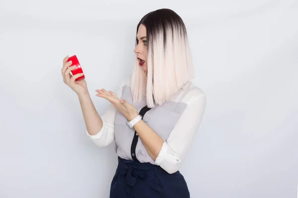 Mulher loira segurando despertador vermelho em suas mãos — Fotografia de Stock