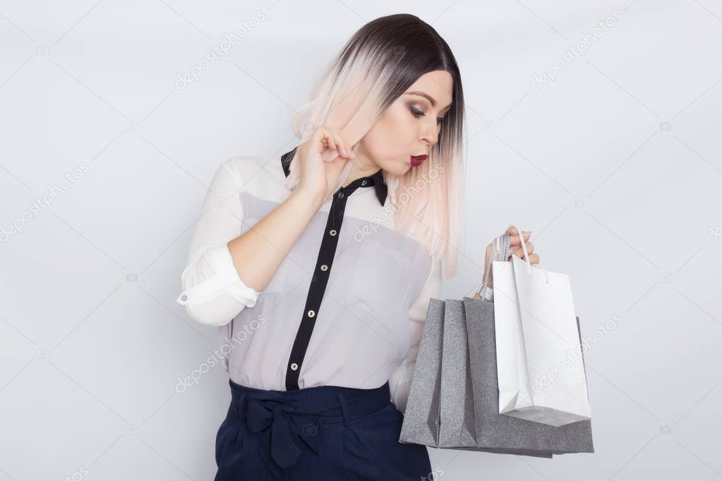 Blonde woman holding shopping bags in her hands