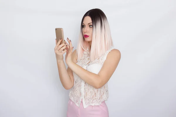Mulher loira segurando telefone celular — Fotografia de Stock