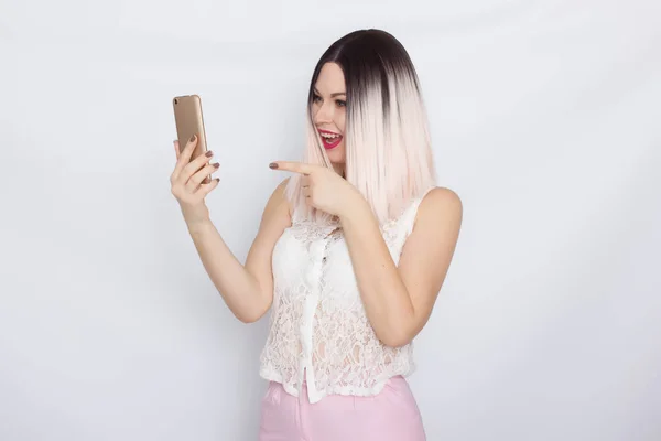 Mulher loira segurando telefone celular — Fotografia de Stock