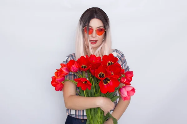 Mulher loira segurando buquê de tulipas vermelhas — Fotografia de Stock