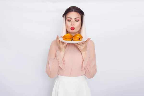 Mulher loira segurando bolos na placa branca — Fotografia de Stock