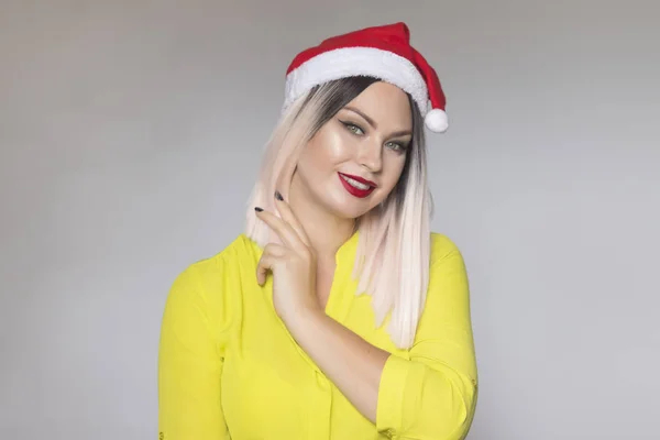 크리스마스 빨간 모자를 입고 아름다운 금발 여성의 스튜디오 초상화 — 스톡 사진