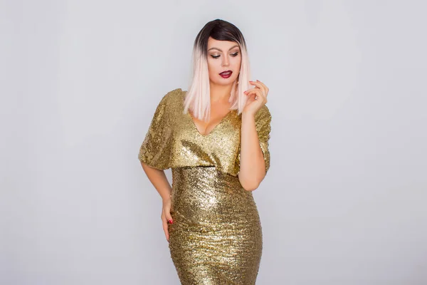 Portrait of a beautiful blonde with bright makeup in a gold dress — Stock Fotó