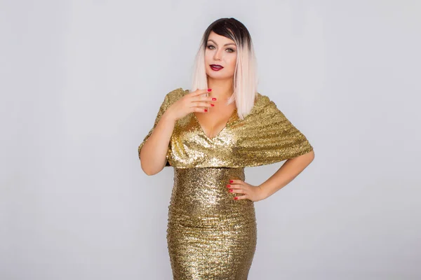 Porträt einer schönen Blondine mit hellem Make-up in einem goldenen Kleid — Stockfoto