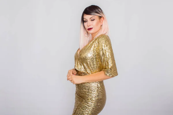 Porträt einer schönen Blondine mit hellem Make-up in einem goldenen Kleid — Stockfoto