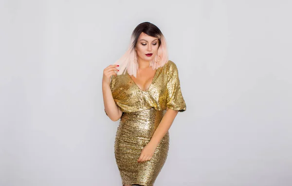 Porträtt av en vacker blondin med ljus makeup i en guld klänning — Stockfoto