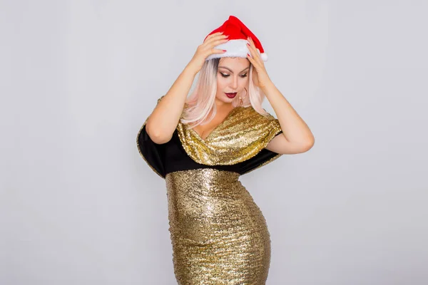 Aufgeregtes junges blondes Haar Frau trägt Weihnachtsmütze und goldenes helles Kleid — Stockfoto