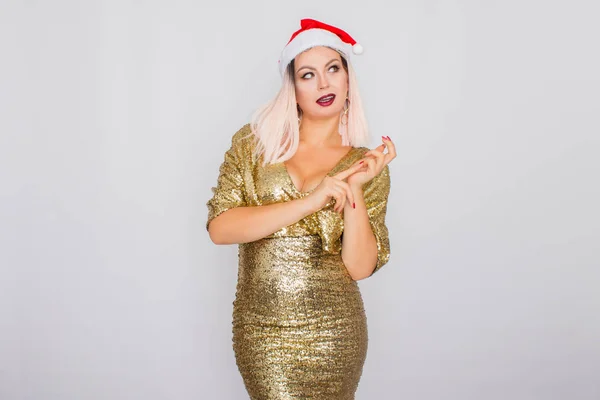 Aufgeregtes junges blondes Haar Frau trägt Weihnachtsmütze und goldenes helles Kleid — Stockfoto