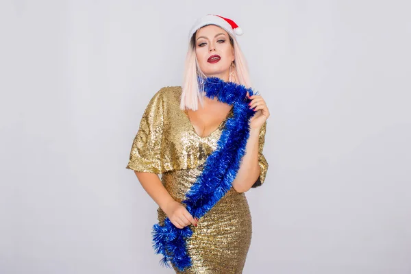 Aufgeregtes junges blondes Haar Frau trägt Weihnachtsmütze und goldenes helles Kleid — Stockfoto