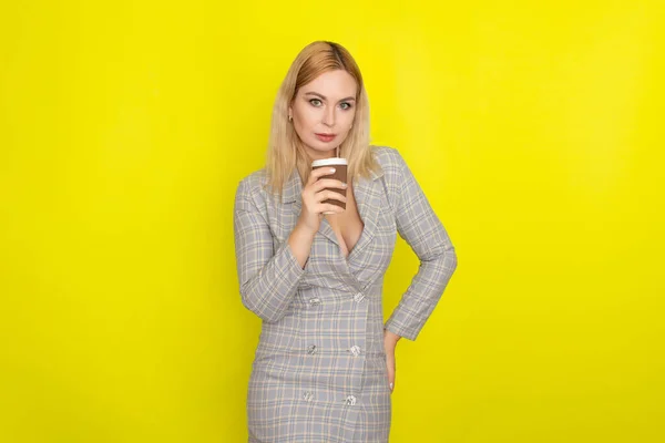 Business Blondine Trägt Kariertes Sakko Und Trinkt Kaffee Vor Gelbem — Stockfoto