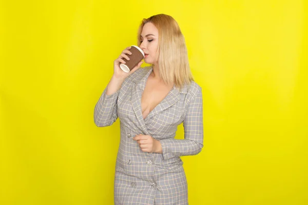 Business Blondine Trägt Kariertes Sakko Und Trinkt Kaffee Vor Gelbem — Stockfoto
