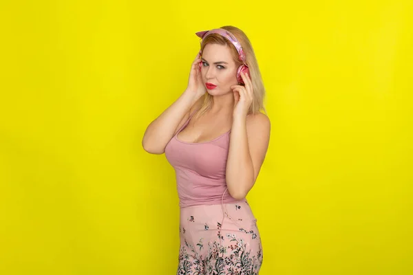 ブロンド女性でピンク夏服を着てピンクのヘッドフォンのような子猫の耳 — ストック写真