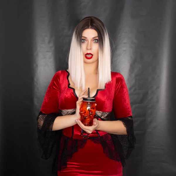 Kırmızı Vampir Elbiseli Genç Sarışın Kadın Ellerinde Kafatası Şeklinde Turuncu — Stok fotoğraf