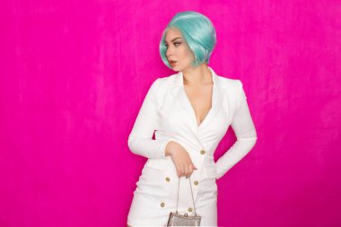 Mentollü kısa saçlı, beyaz bir iş elbisesi içinde, elinde gümüş bir el çantası olan güzel bir genç kadın.