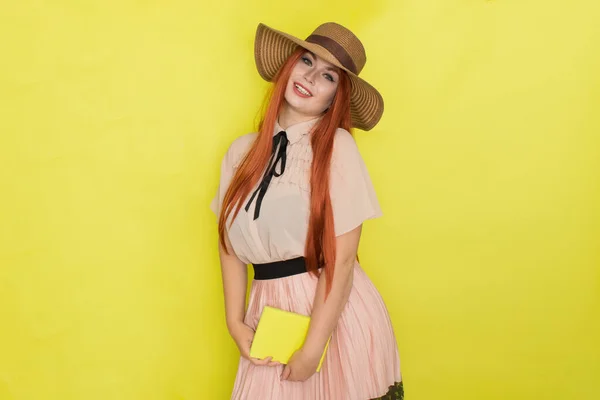 Mujer Pelirroja Con Sombrero Paja Sobre Fondo Amarillo Sosteniendo Libro — Foto de Stock