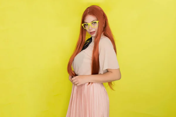 黄色の背景 スタジオ スタイルの上に眼鏡やオフィスの服を持つ赤い髪の女性 — ストック写真