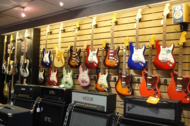 Müzik mağazasının duvarında asılı modern gitar koleksiyonu 