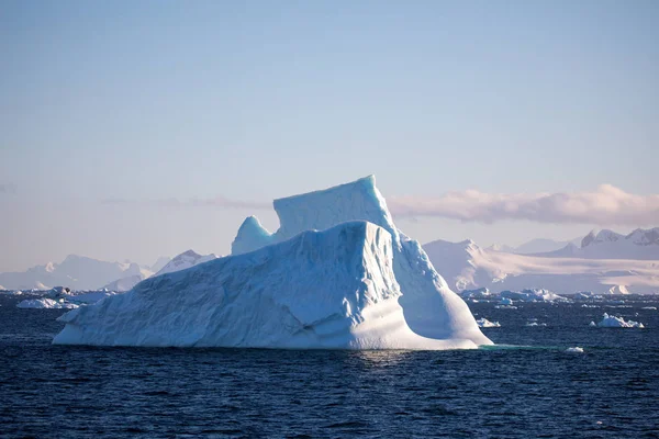 icecaps in the Antarctica with iceberg in the ocean swimming around and melting in the sea