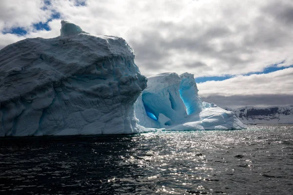 icecaps in the Antarctica with iceberg in the ocean swimming around and melting in the sea