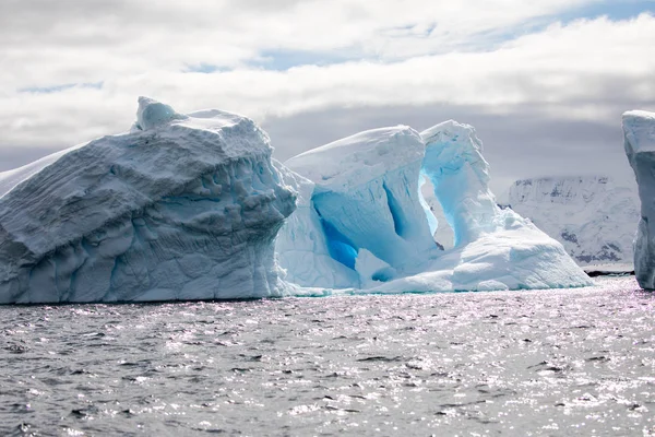 icecaps in the Antarctica with iceberg in the ocean swimming around and melting in the sea