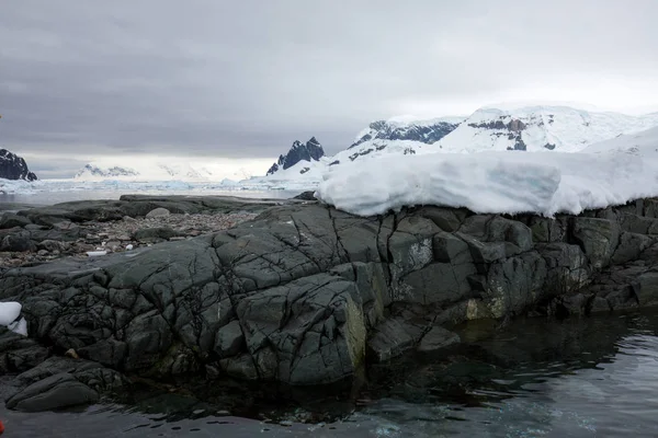 icecaps in the Antarctica with iceberg in the ocean swimming around and melting in the sea