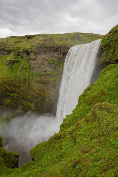 a waterfall in iceland between the mountains from the river spring