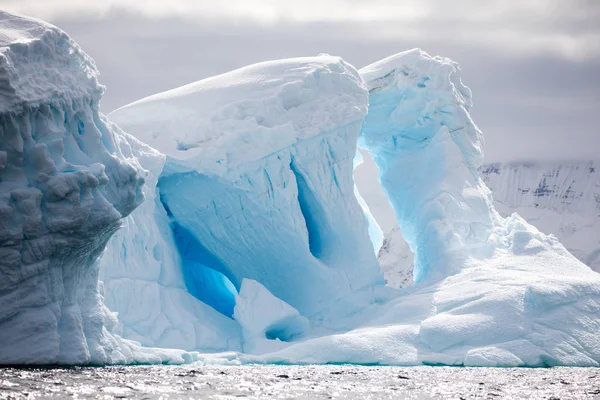 icecaps in the Antarctica with iceberg in the ocean swimming around and melting in the sea