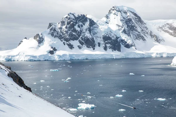 icecaps in the Antarctica with iceberg in the ocean swimming around and melting in the sea