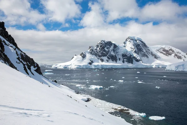 icecaps in the Antarctica with iceberg in the ocean swimming around and melting in the sea