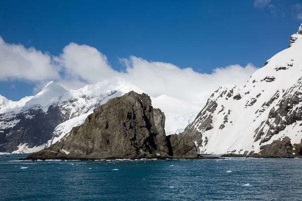 icecaps in the Antarctica with iceberg in the ocean swimming around and melting in the sea