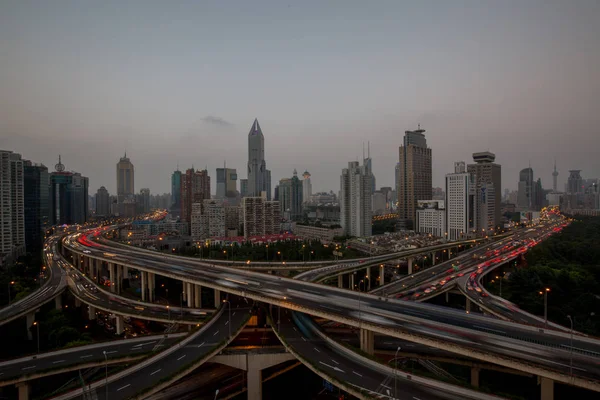 a city in asia with traffic and a river between skyscrapers