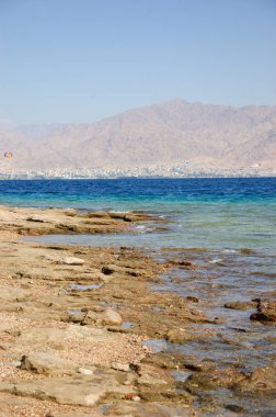Eilat'ın Mercan Plajı'ndan Ürdün'deki Akabe'ye doğru manzara (Eilat. Israe). Eilat Coral Beach Doğa Rezerv, dünyanın en güzel mercan resifi biri, ünlü turistik ve dalgıç cazibe olduğunu.