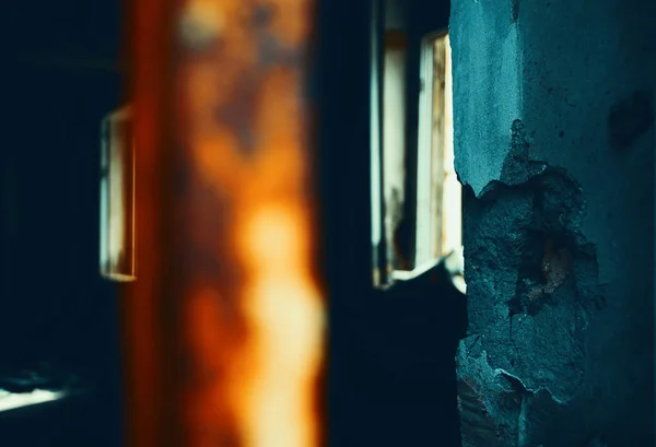 Habitación destruida en un edificio abandonado. Los rayos del sol iluminan el desordenado interior apocalíptico. Concepto de decadencia. Foto tonificada . — Foto de Stock