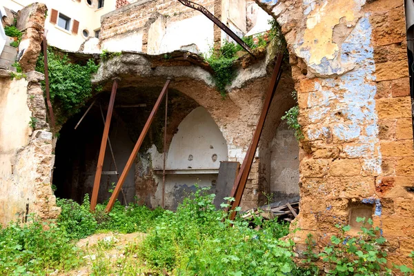 Konut binasının yakınındaki terk edilmiş harabe ev. Paslı metal pervaneler tarafından desteklenen kırık taş duvar ve kemerler. Tehlike kavramlarını daralt. Güvenlik sorunu arka planı. 