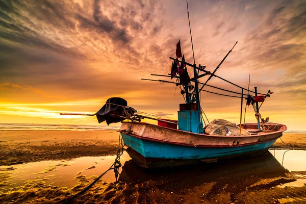 Beautiful sunrise over an old wooden fishing boat on a pebble be — Stock Photo, Image