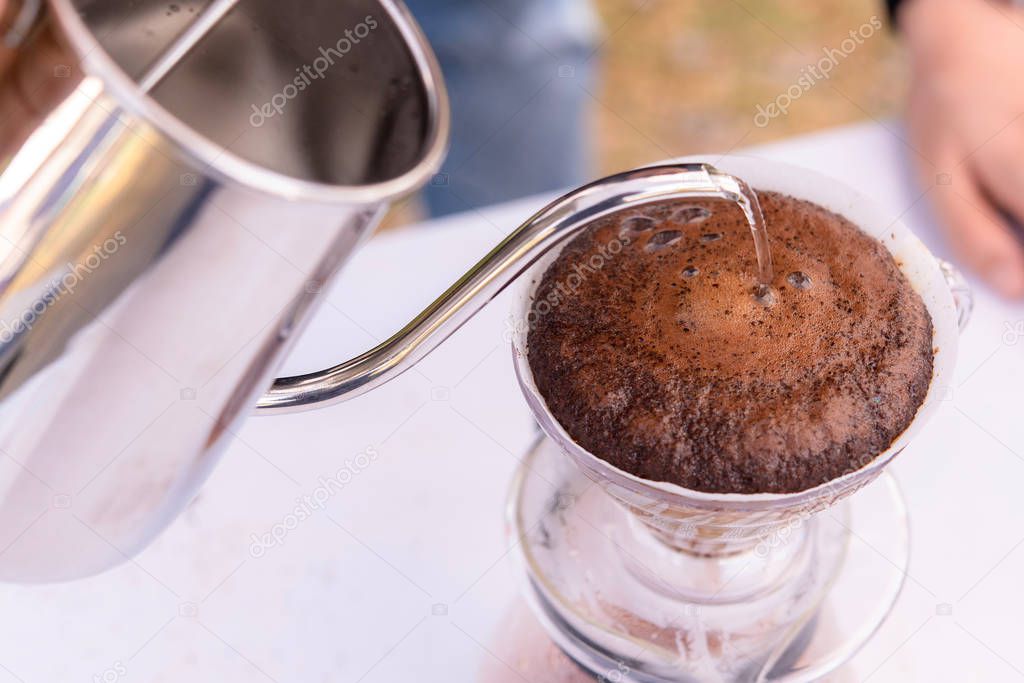 Pouring hot water on ground coffee, hand drip coffee