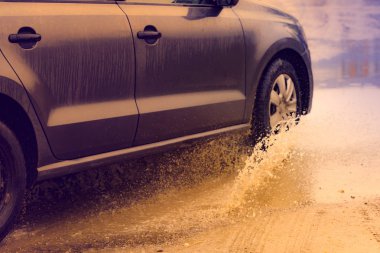 Hareket eden araba yağmuru Tekerleklerden fışkıran su birikintisi