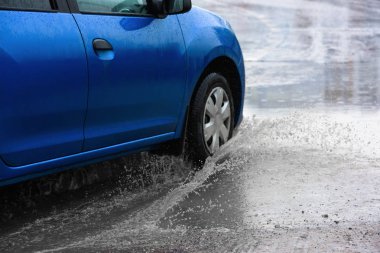 Hareket eden araba yağmuru Tekerleklerden fışkıran su birikintisi