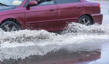 Hareket eden araba yağmuru Tekerleklerden fışkıran su birikintisi