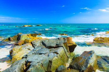 Vietnam'da bir bulut ile mavi gökyüzüne karşı Güney Çin Denizi'nin güzel taşlı sahil